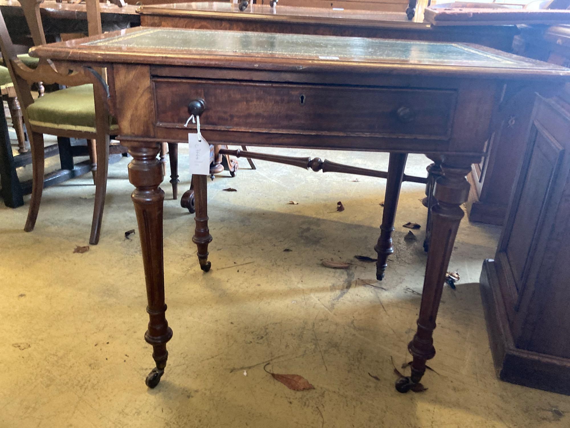 A late Victorian mahogany writing table, with leather lined top and ceramic castors, width 88cm